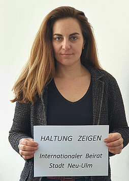 Eine Frau mit dem Plakat „Haltung zeigen. Neu-Ulm für Frieden und Zusammenhalt“
