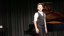 Junge vor einem Klavier
