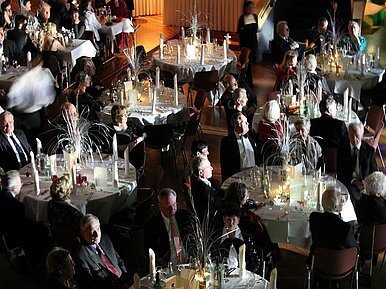 Großer Saal mit gedeckten und feierlich geschmückten runden Tischen im ESH