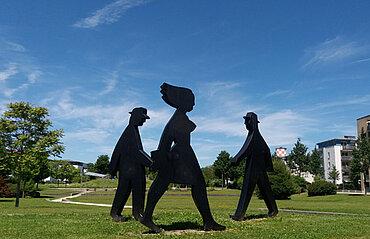 Drei überlebensgroße schwarze Skulpturen im Form von Personen