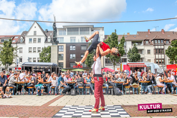 Zwei Akrobatikkünstler unterhalten das Publikum auf dem Neu-Ulmer Rathausplatz