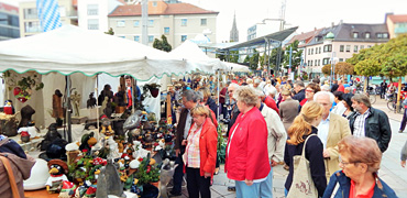 Besucher des verkaufsoffenen Sonntages bummeln über Marktstände auf dem Petrusplatz in Neu-Ulm