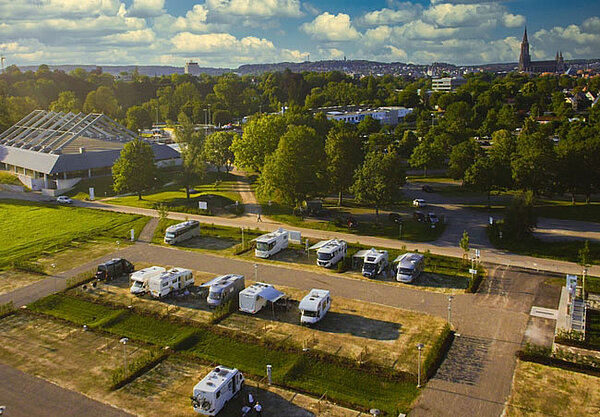 Luftaufnahme mit Blick auf den Wohnmobilstellplatz, im Hintergrund das Ulmer Münster
