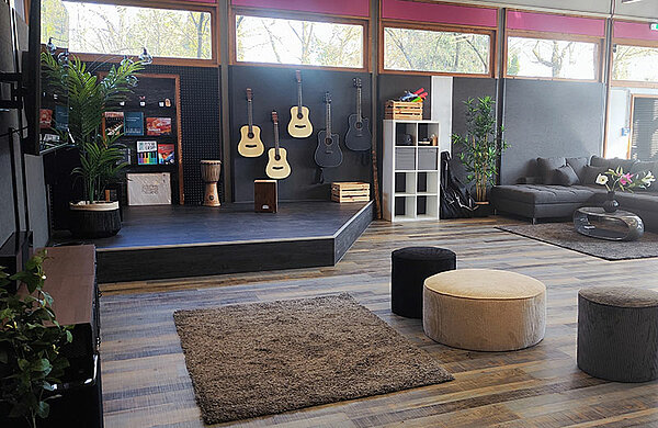 Großer Freizeitraum im Jugendhaus mit Sitzmöbeln und Instrumenten