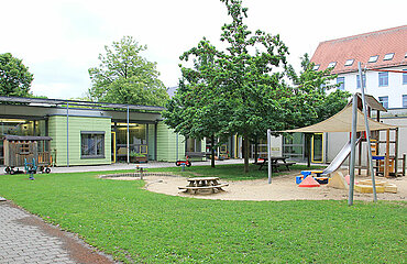 Kinderspielplatz mit Kletterturm, Rutsche, Sandspielbereich und Wippen