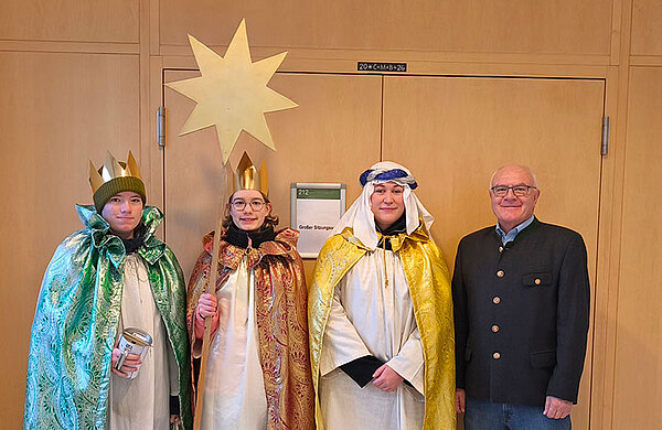 Die Sternsinger mit einem Stern stehen neben Neu-Ulms zweitem Bürgermeister Johannes Stingl