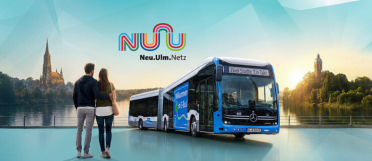 Ein Paar blickt auf die Skyline von Ulm und Neu-Ulm, neben ihnen ein Elektrobus mit der Aufschrift "Zwei Städte. Ein Takt."