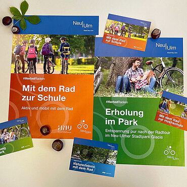Postkarten und Plakate zur Radl-Kampagne mit verschiedenen Radfahrmotiven, u.a. zum Thema "Erholung im Park" und "Mit dem Rad zur Schule"