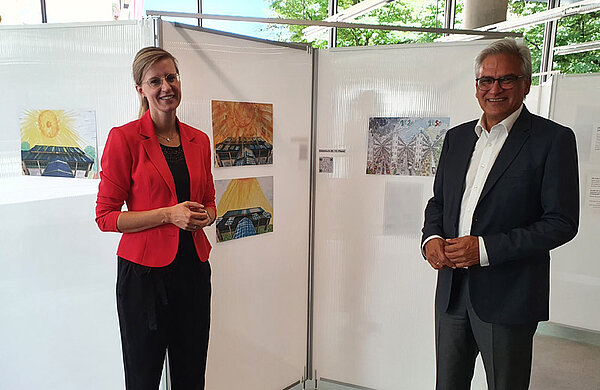 Neu-Ulms Oberbürgermeisterin Katrin Albsteiger und Ulms Oberbürgermeister Gunter Czisch vor einer Tafel mit ausgestellten Bildern