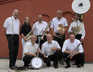 Bandfoto der acht Musiker der "Black Hat Stompers" mit Instrumenten
