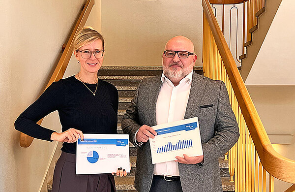 Oberbürgermeisterin Katrin Albsteiger und Stadtkämmerer Gregor Kamp mit Ausdrucken der Haushaltszahlen in Diagrammform