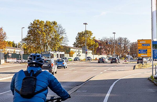 Mehrere Autos und ein Radfahrer fahren Richtung Kreuzung Memminger Straße / B10.