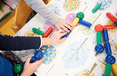 Kinderhände greifen nach Bausteinen