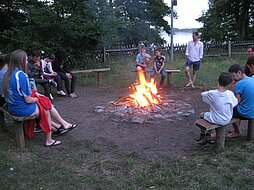 Jugendliche sitzen um ein Lagerfeuer