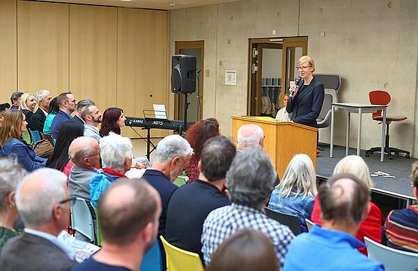 Oberbürgermeisterin Katrin Albsteiger spricht vor Zuhörern an einem Redepult in ein Mikrophon