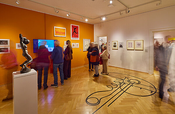 Besucher in der Kunst-Ausstellung mit Bildern, Skulpturen und Video-Beiträgen