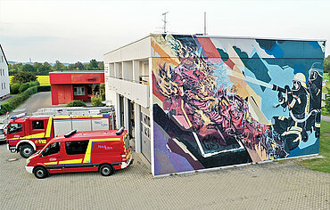 Feuerwehr-Gerätehaus mit Feuerwehr-Motiv auf der Fassade