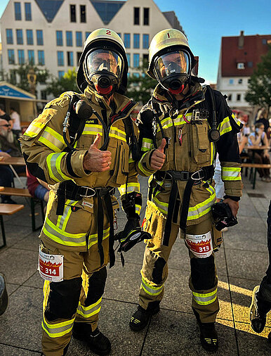 Zwei Feuerwehrkameraden in Brandschutzausrüstung und mit Atemschutzgerät