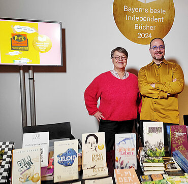 Verlegerin Annette Stroux und Autor Florian L. Arnold hinter einem Büchertisch