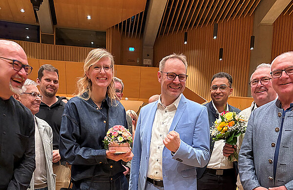 Oberbürgermeisterin Katrin Albsteiger bei der Verkündung der Wahlergebnisse mit Blumen in der Hand und umringt von Parteikolleginnen und -kollegen