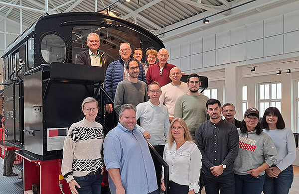 Gruppenfoto der Mitarbeiterinnen und Mitarbeiter der Stadtverwaltungen Neu-Ulm und Meiningen vor einer Dampflok