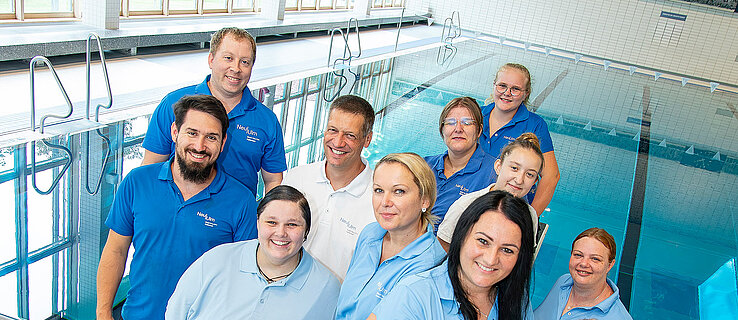 Gruppenfoto mit Mitarbeitenden des Hallenbades vor dem Schwimmbecken