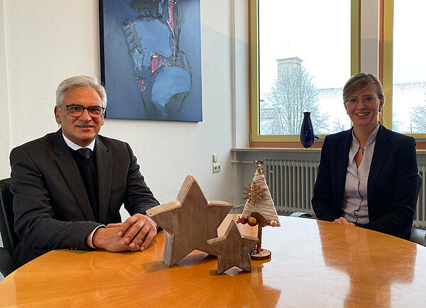 Neu-Ulms Oberbürgermeisterin Katrin Albsteiger und Ulms Oberbürgermeister Gunter Czisch sitzen gemeinsam an einem runden Tisch und blicken in die Kamera.