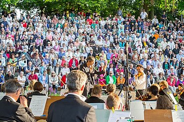 Konzert eines Orchesters vor vollbesetzten Pulikumsrängen im Glacis-Park