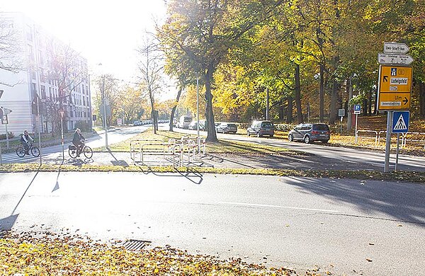 Radfahrer fahren an einem Kreisverkehr entlang