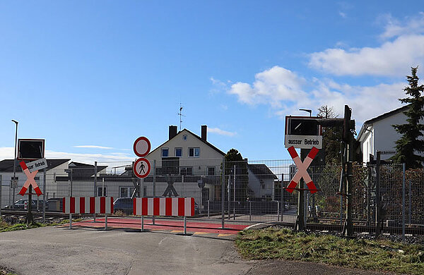Der Bahnübergang ist mit einem Zaun gesperrt und zusätzlich mit den Schilden "außer Betrieb" und "Verbot für Fußgänger" sowie "Verbot für Fahrzeuge" versehen.
