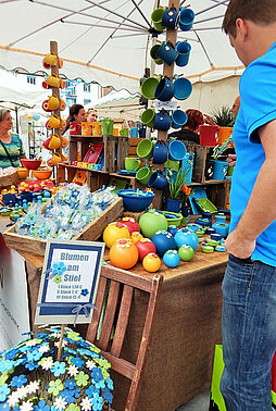 Marktstand mit bunten Tassen und Dekoblumen aus Ton bzw. Keramik