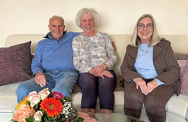 Neu-Ulms dritte Bürgermeisterin neben den beiden Eheleuten auf einer Couch.