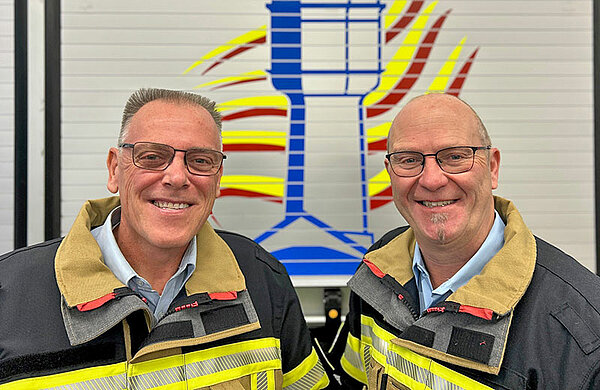 Feuerwehr-Kommandant Andreas Hoffzimmer und sein Stellvertreter Michael Haitchi in Feuerwehr-Schutzkleidung.
