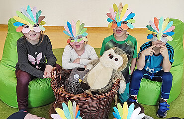 Kinder mit bunt bemalter Papiermaske im Gesicht