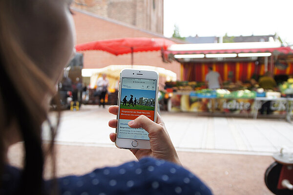 Blick über die Schulter eine Frau, die mit dem Smartphone im Internet surft