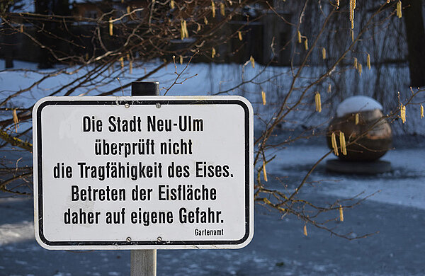 zugefrorene Eisfläche mit Warnschild