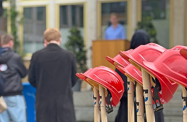 Spaten mit Baustellenhelmen