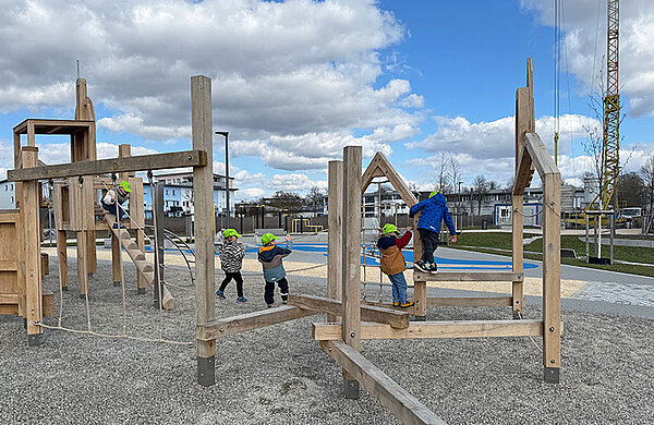 Kinder spielen im Kletterbereich des Spielplatzes.
