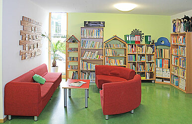 Leseraum mit Couch und Bücherregalen