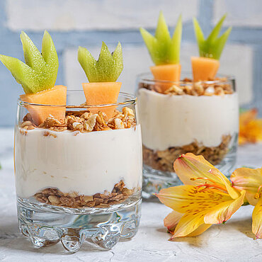 Zwei Gläser mit Joghurt, Müsli und Obst