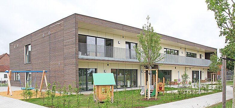 Außenansicht der Kita mit Spielplatz