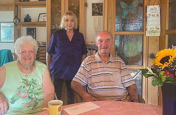 Rosl Schäufele steht hinter dem sitzenden Ehepaar