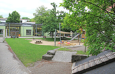 Kinderspielplatz mit Kletterturm, Rutsche, Sandspielbereich und Wippen