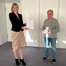 Georg Schlaier hält die Bürgermedaille in den Händen, Oberbürgermeisterin Katrin Albsteiger überreicht ihm eine Urkunde.