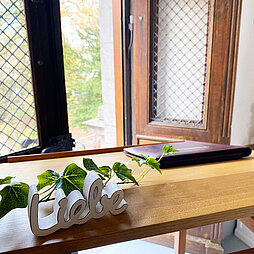 Holztisch mit einem Dekoobjekt mit dem Schriftzug LIEBE