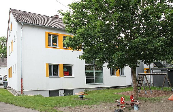 Außenansicht der Kita mit Spielplatz