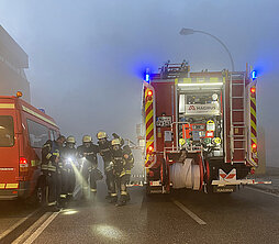 Gruppenfoto der Feuerwehrkameraden mit Feuerwehrausrüstung neben einem Löschfahrzeug