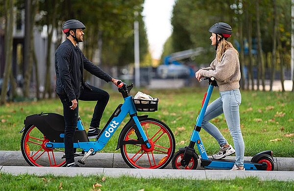 Eine Person mit einem E-Pedelec und eine Person mit einem E-Scooter, beide mit Helm