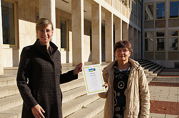 Oberbürgermeisterin Katrin Albsteiger und Ute Seibt halten die Urkunde zur Rezertifizierung der Stadt Neu-Ulm als Fairtrade-Stadt in Händen.