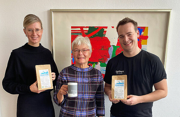 Die aufgeführten Personen halten zwei Packungen mit dem Neu-Ulmer Stadtkaffee und eine Kaffeetasse in ihren Händen.